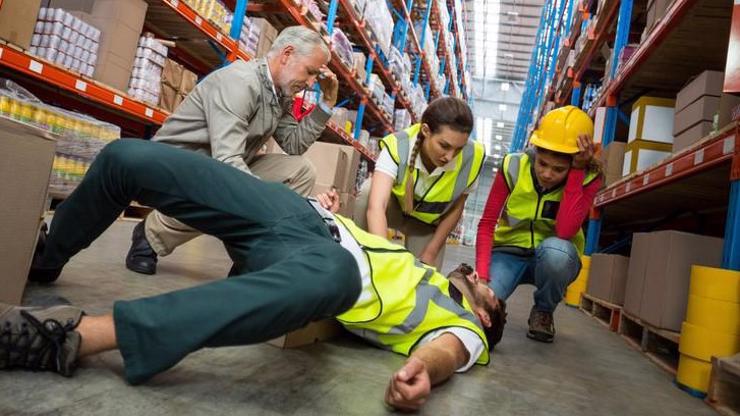 Coworkers checking on a man who suffered an injury on the job