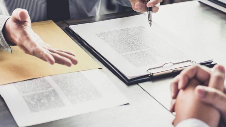 Two people meeting over documents at a desk.