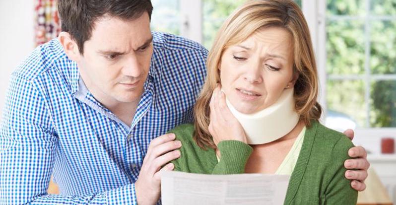 This image shows a woman in a neckbrace reviewing a document.