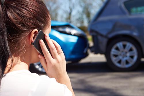 A woman calling her insurance after a rear-end car accident.