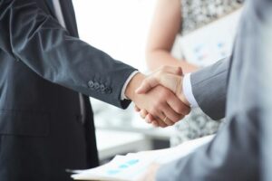 Image is of a Marietta car accident lawyer shaking hands with happy client
