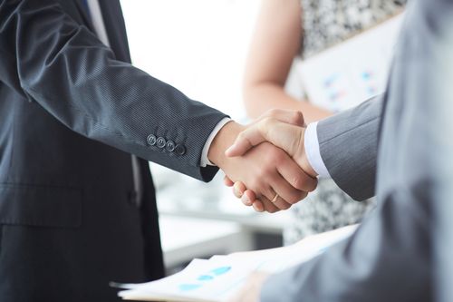 Image is of a Marietta car accident lawyer shaking hands with happy client